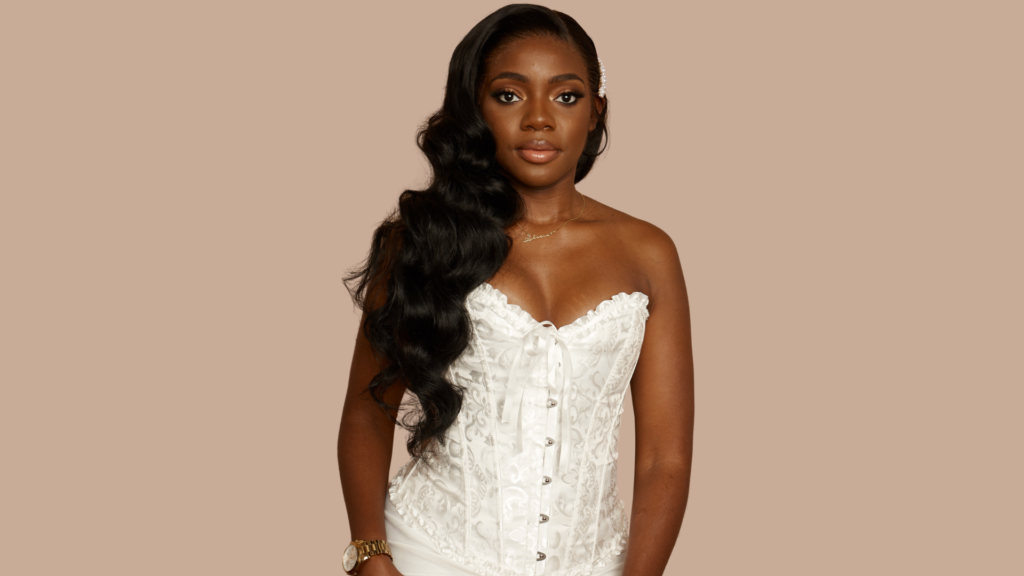 Woman in white corset top showcasing long, styled hair, representing Indish Beauty's bridal and custom wig services.